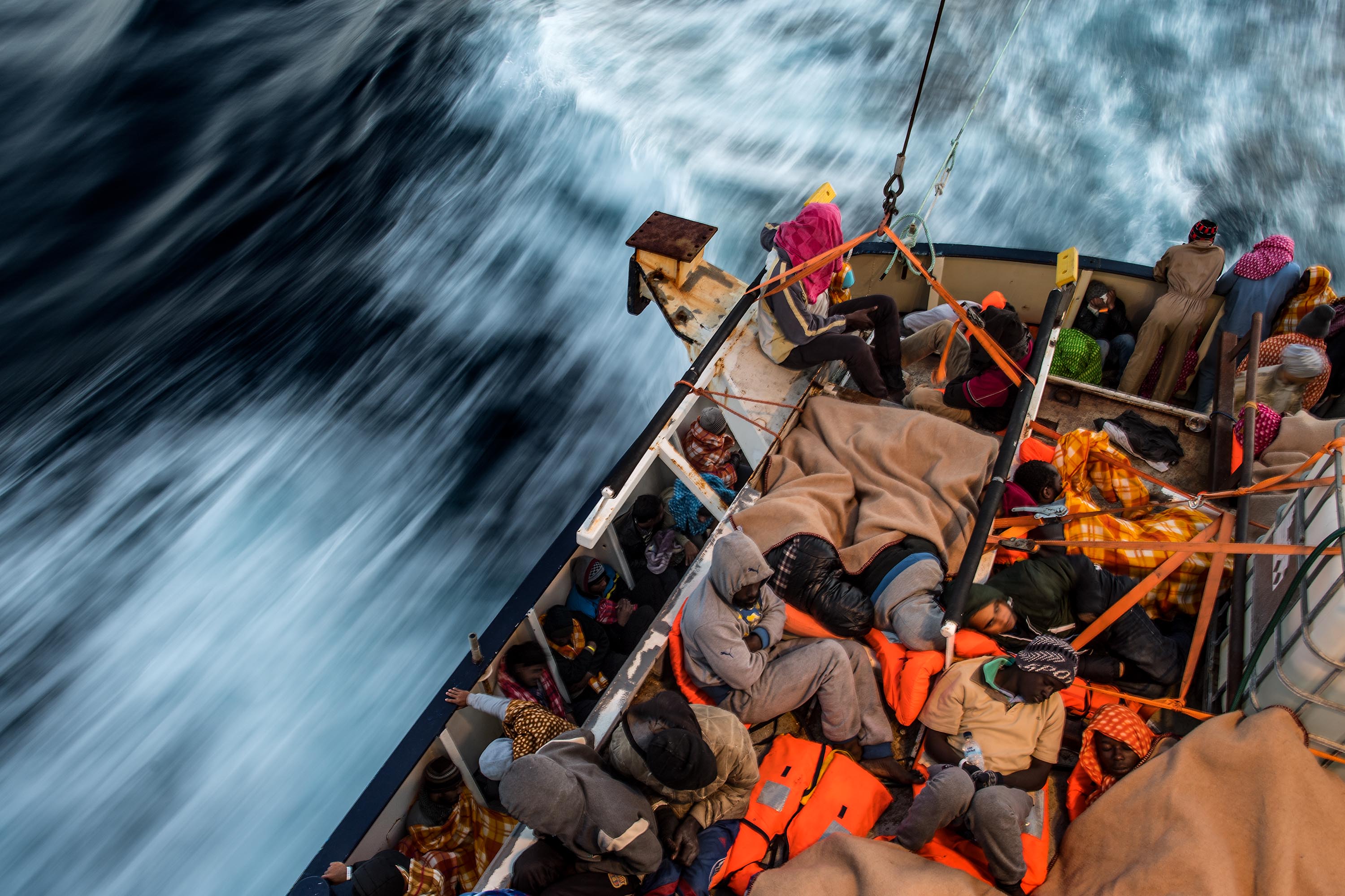A picture of migrants packed together tightly in a boat sailing on the sea.