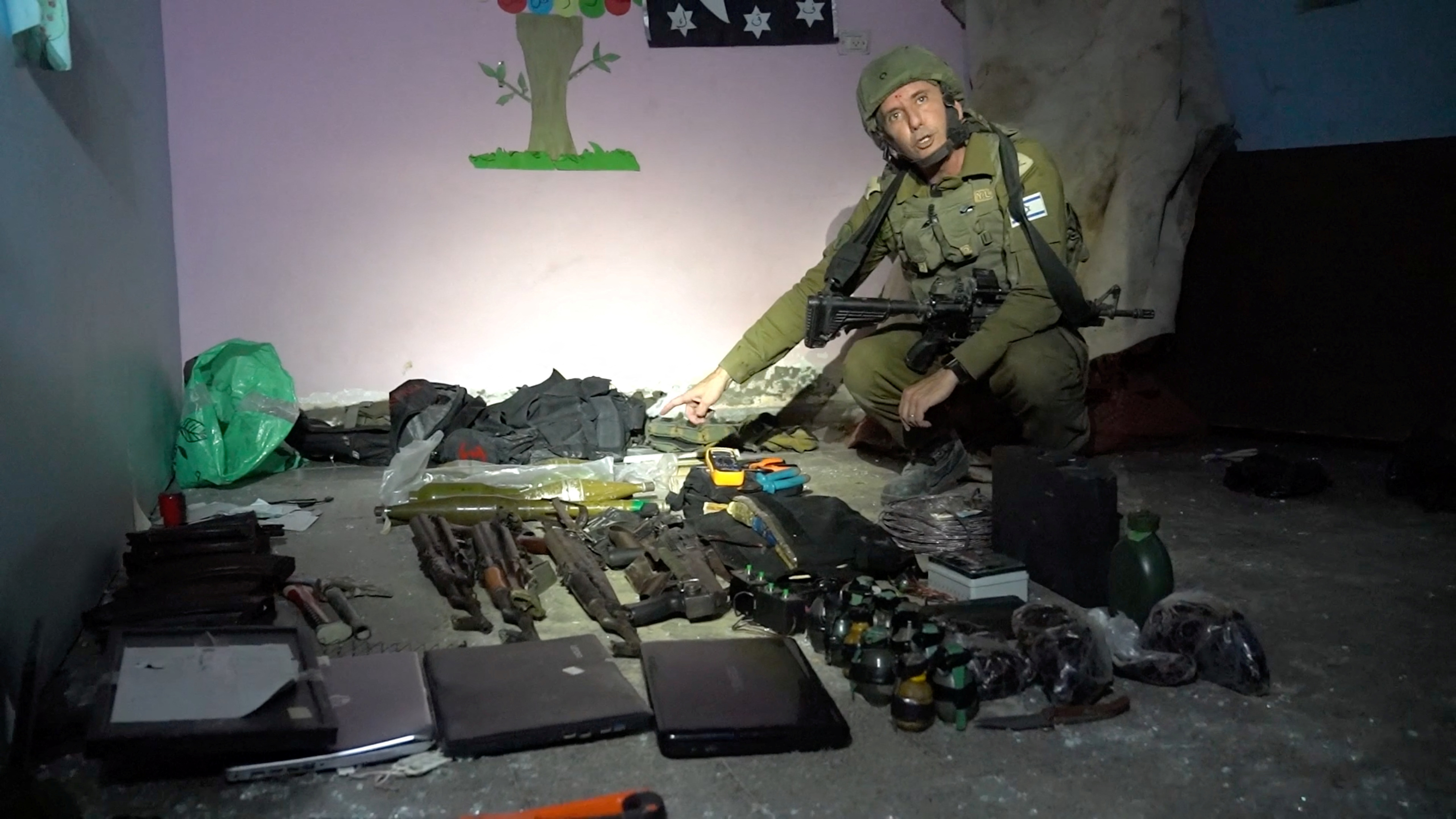 Israeli military spokesperson Daniel Hagari shows what he says are weapons stored by Hamas in the basement of Rantissi Hospital, a paediatric hospital with a specialty in treating cancer patients, at a location given as Gaza. (14/11/2023) 
