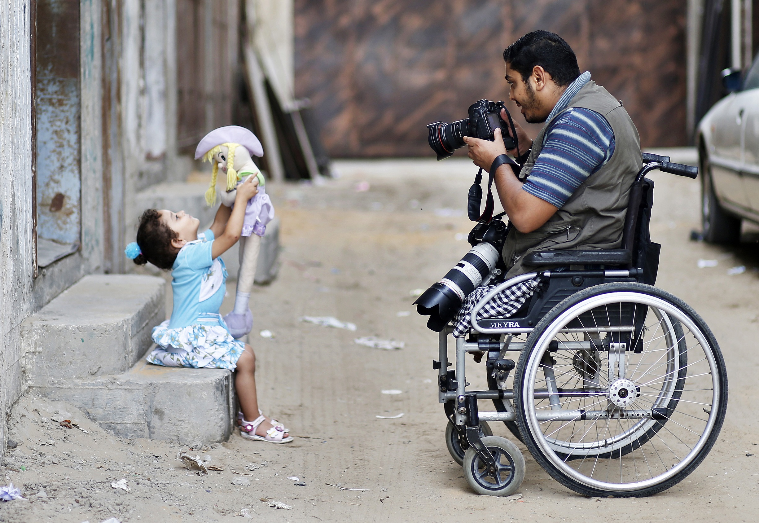 المصور الفلسطيني مؤمن قريقع يصور ابنته أمام منزله في غزة (رويترز) 