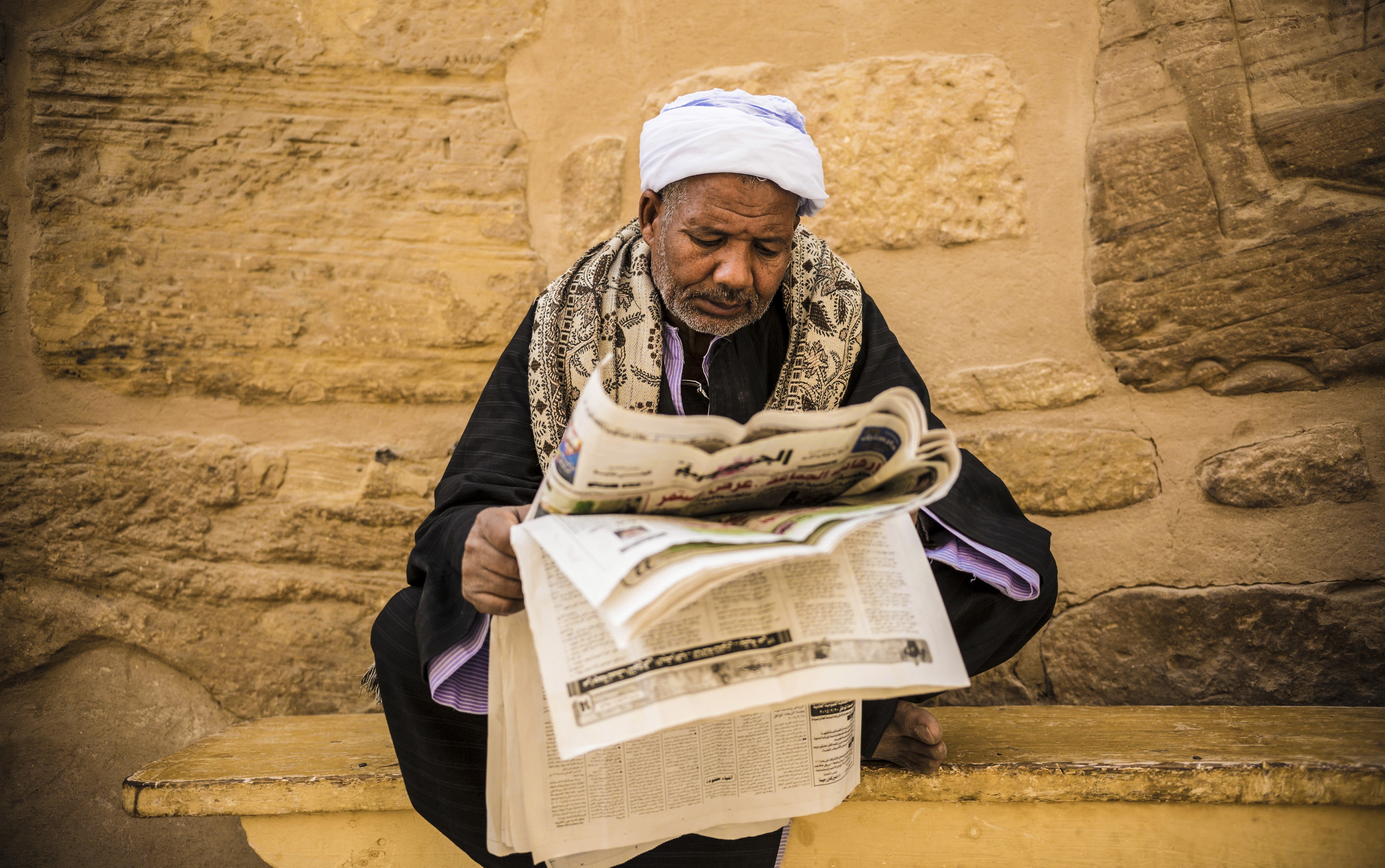 A tourist guide reads newspaper at Ramesses III. Mortuary Temple, also known as Medinet Habu Complex in west of Luxor, Egypt on February 19, 2015.