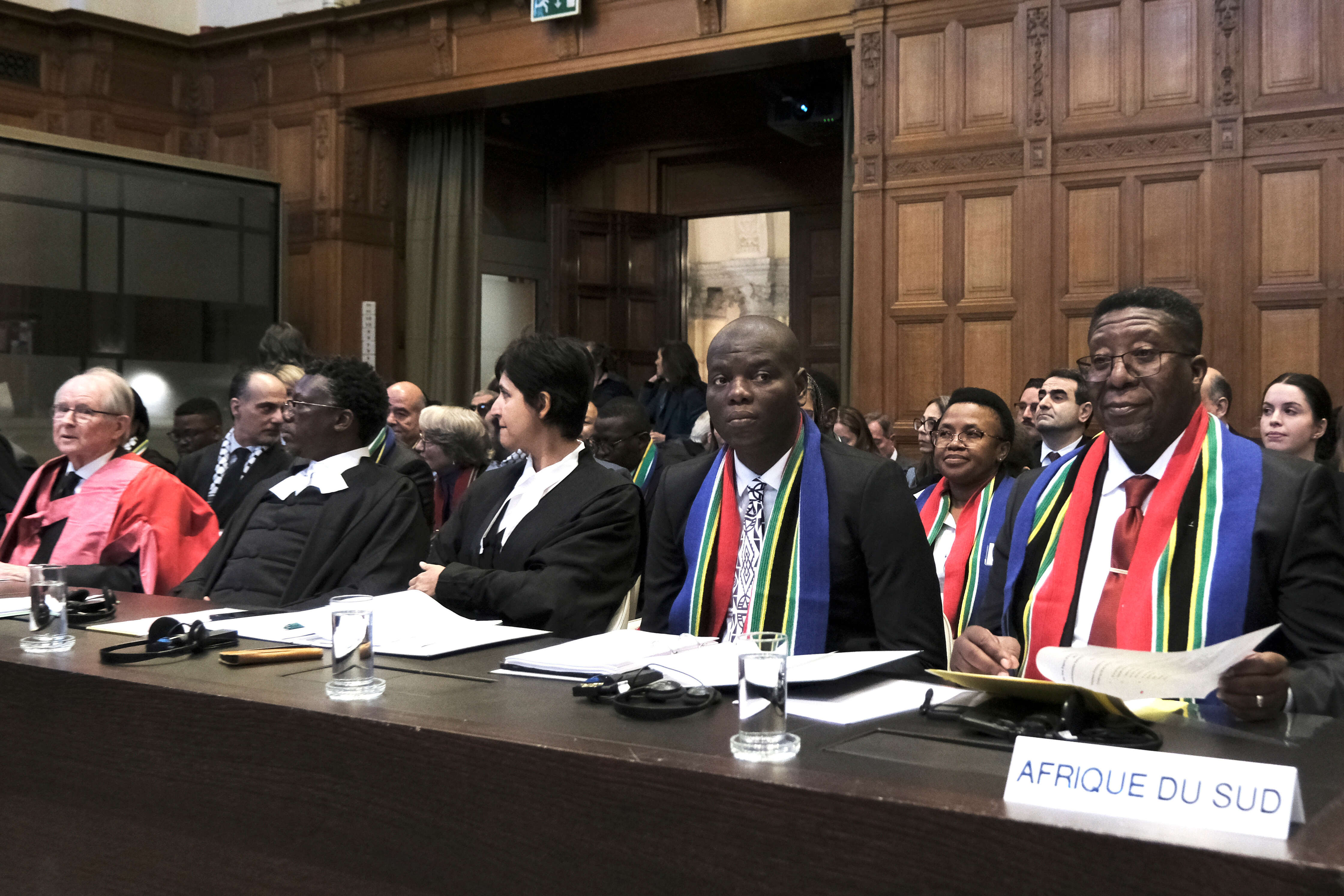 Ambassador of the Republic of South Africa to the Netherlands Vusimuzi Madonsela, right, and Minister of Justice and Correctional Services of South Africa Ronald Lamola, center, during the opening of the hearings at the International Court of Justice in The Hague, Netherlands, Thursday, Jan. 11, 2024. The United Nations' top court opens hearings Thursday into South Africa's allegation that Israel's war with Hamas amounts to genocide against Palestinians, a claim that Israel strongly denies. (AP Photo/Patric