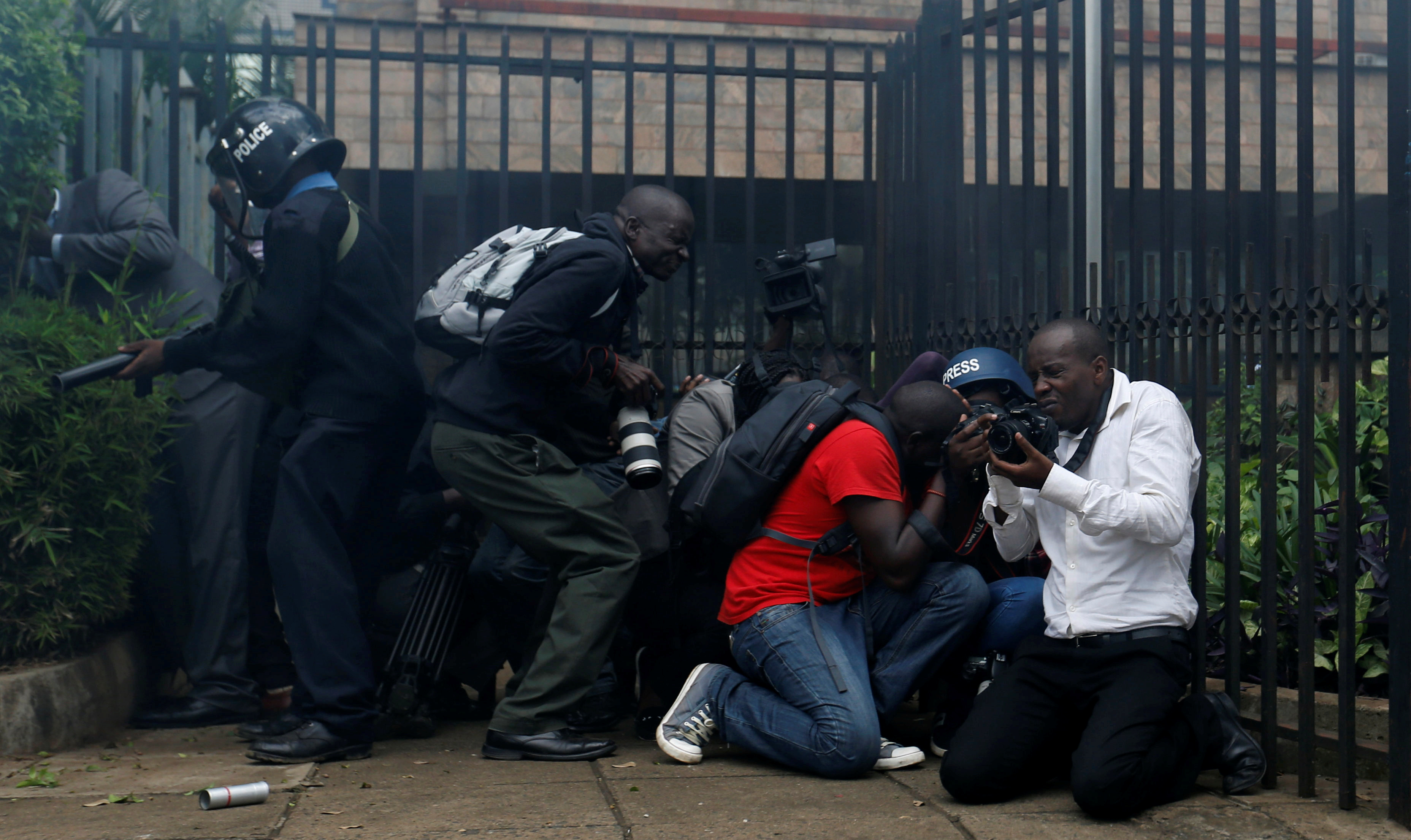 Journalists and riot-police take cover after riot police 