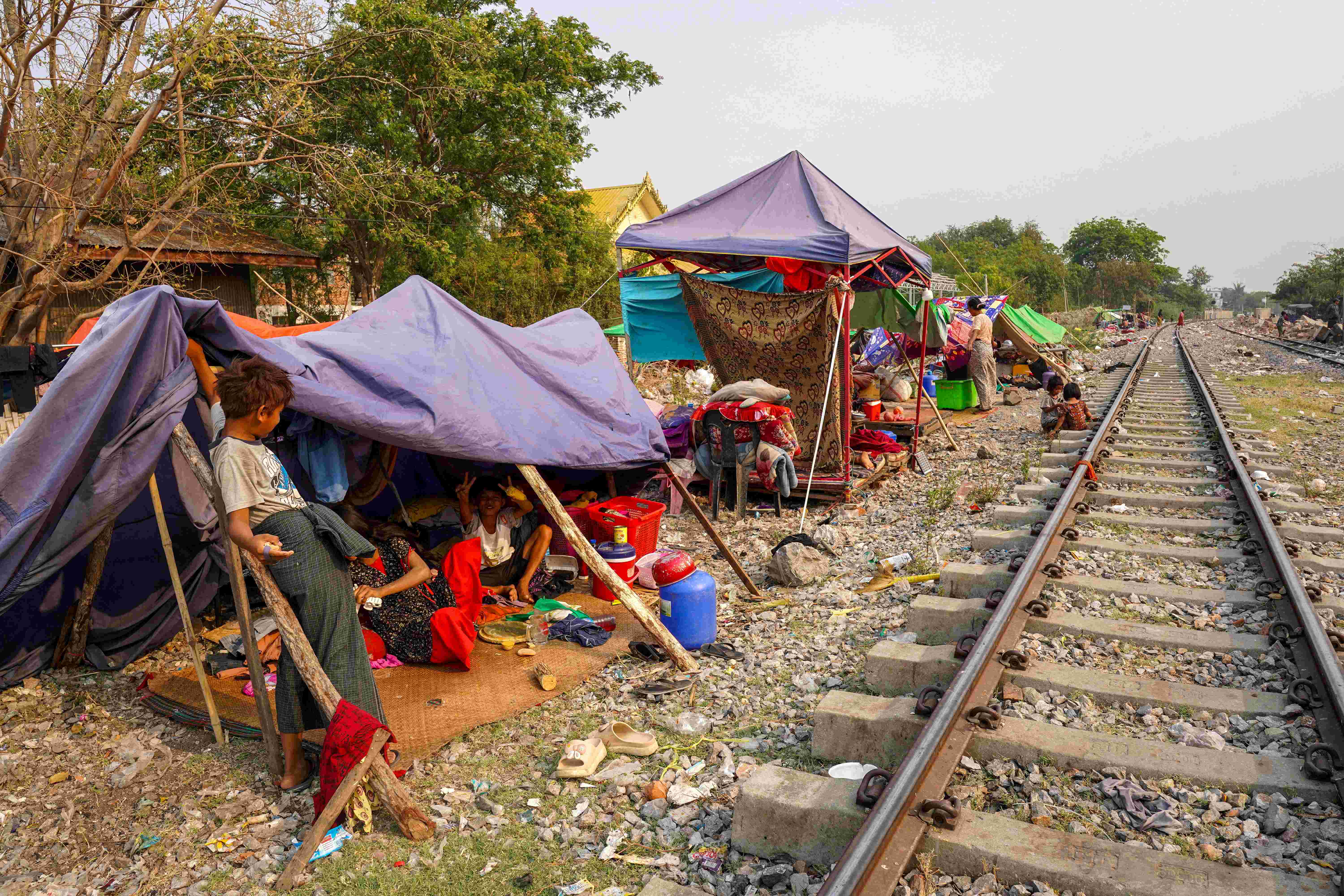 People are seen at a shelter in a makeshift tent camp near a railway track, following a strong earthquake in Amarapura township, Myanmar, April 4, 2025. 