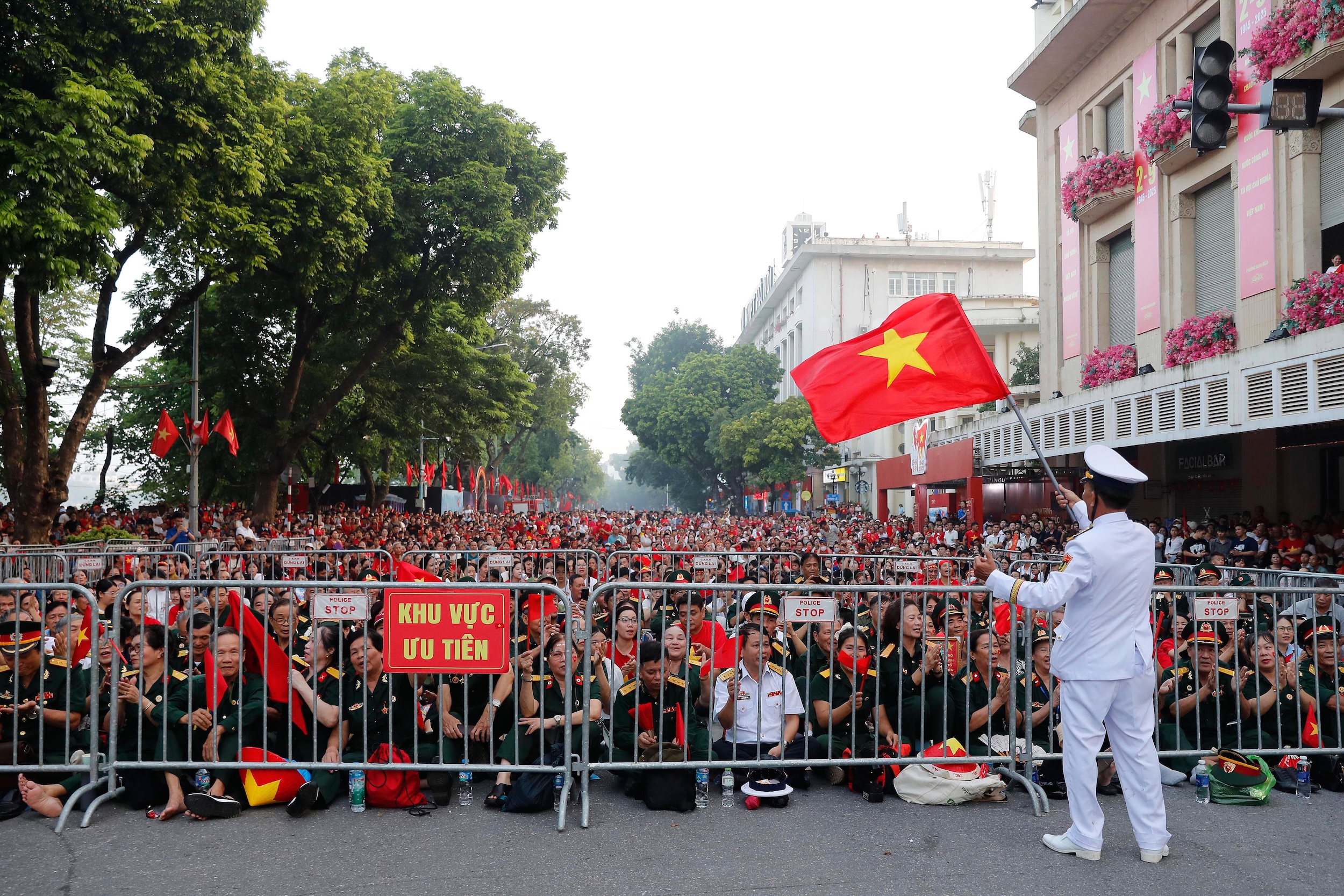 People wait to watch a parade marking Vietnam's 80th National Day anniversary, at a street in Hanoi, Vietnam Tuesday, Sept. 2, 2025. (Luong Thai Linh/Pool Photo via AP)