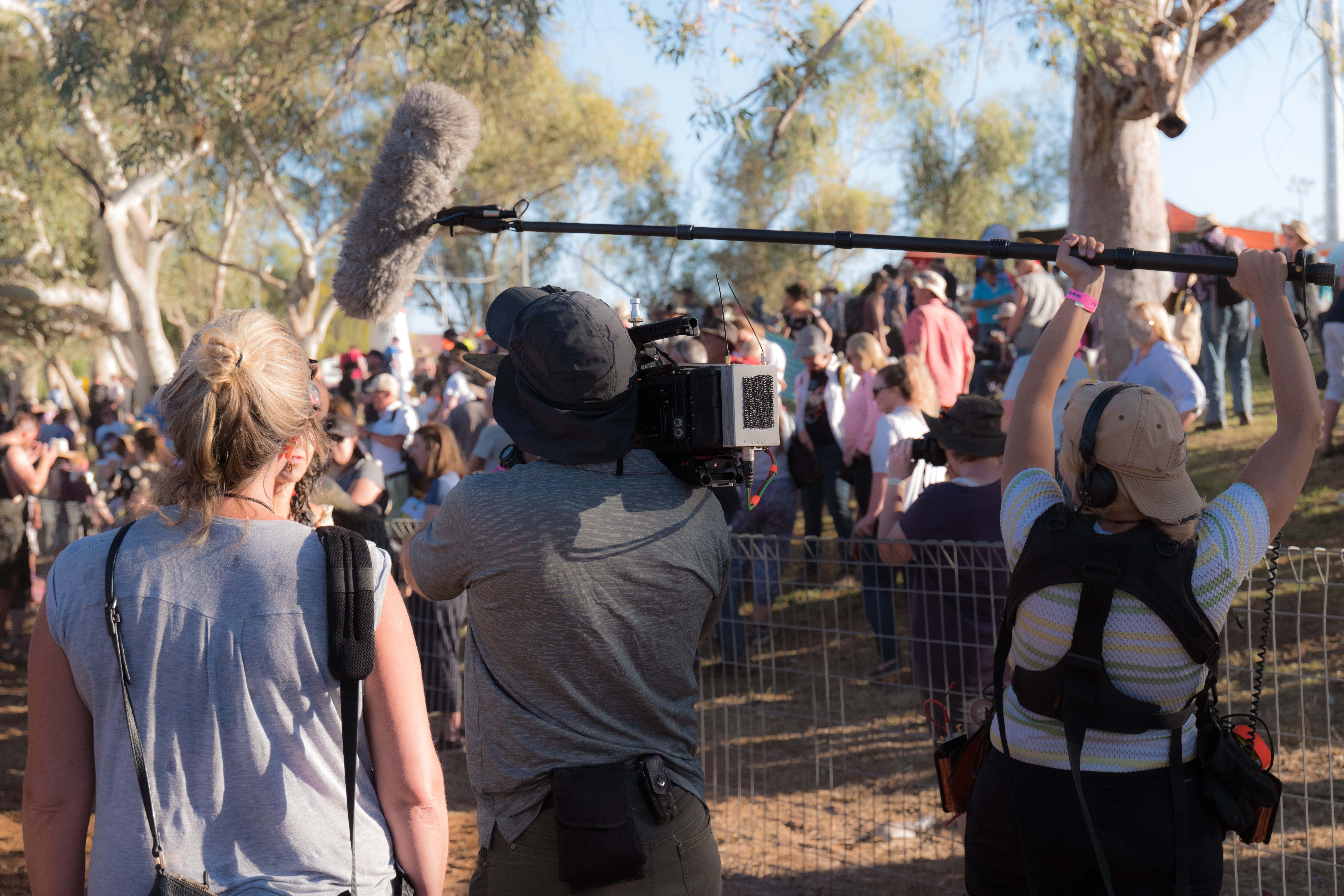 A large group of Western Journalists in the field waiting for a statement 