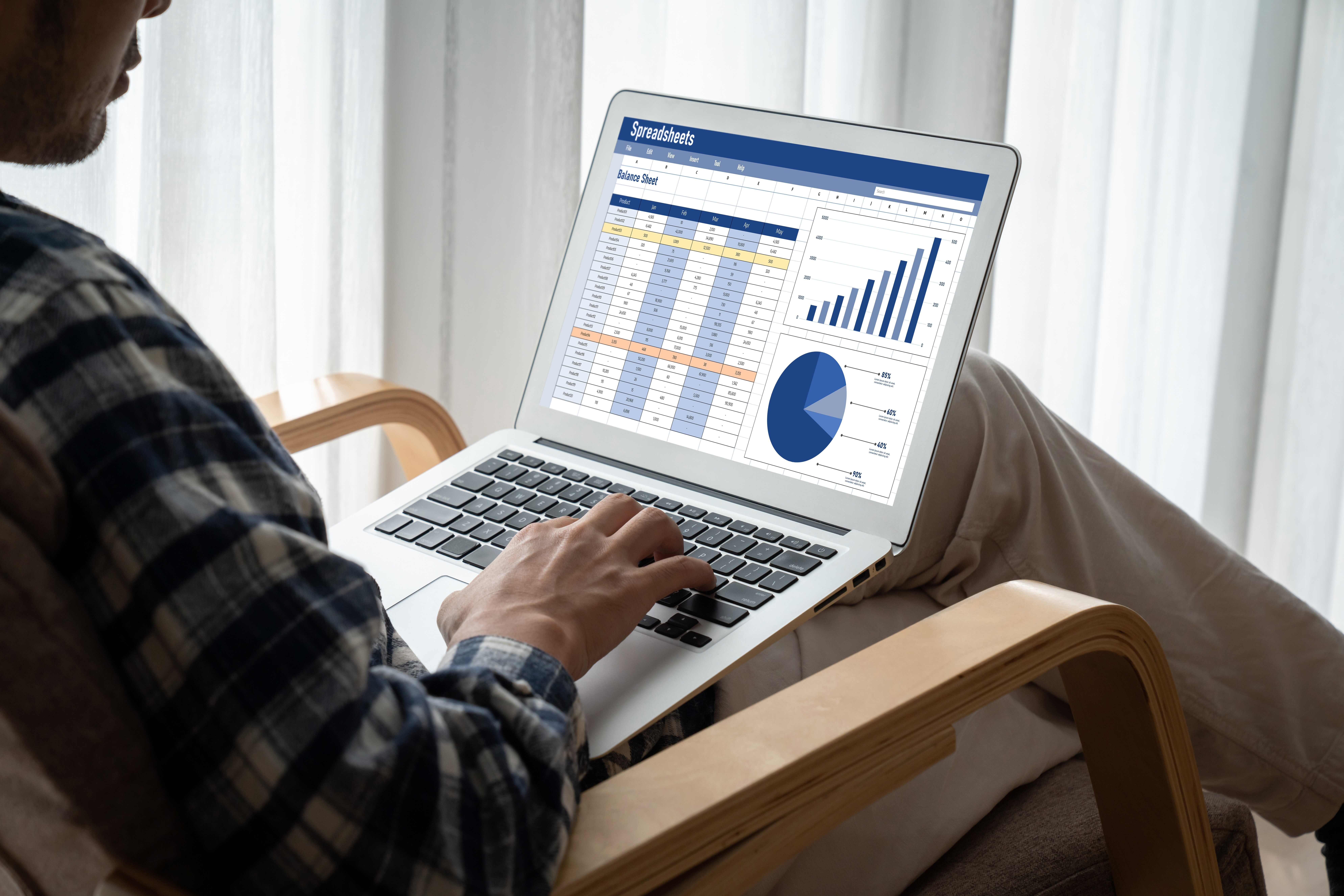 A man looking at a computer screen that displays a pie chart and data, working on data journalism material. 
