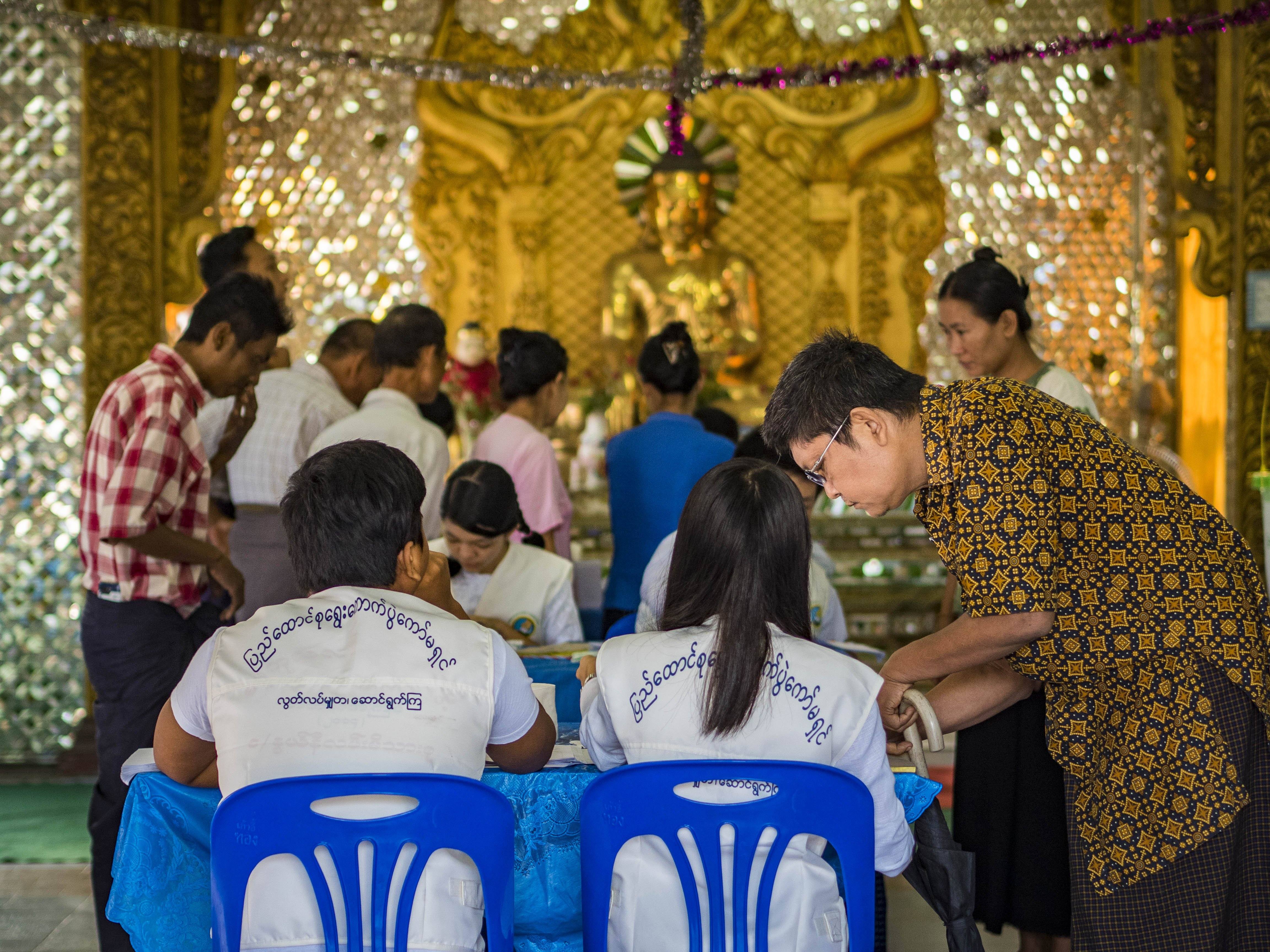 Nov. 8, 2015 - Yangon, Yangon Division, Myanmar - A man gets his ballot in his polling place in a Buddhist temple in North Okkalapa, a township outside central Yangon.