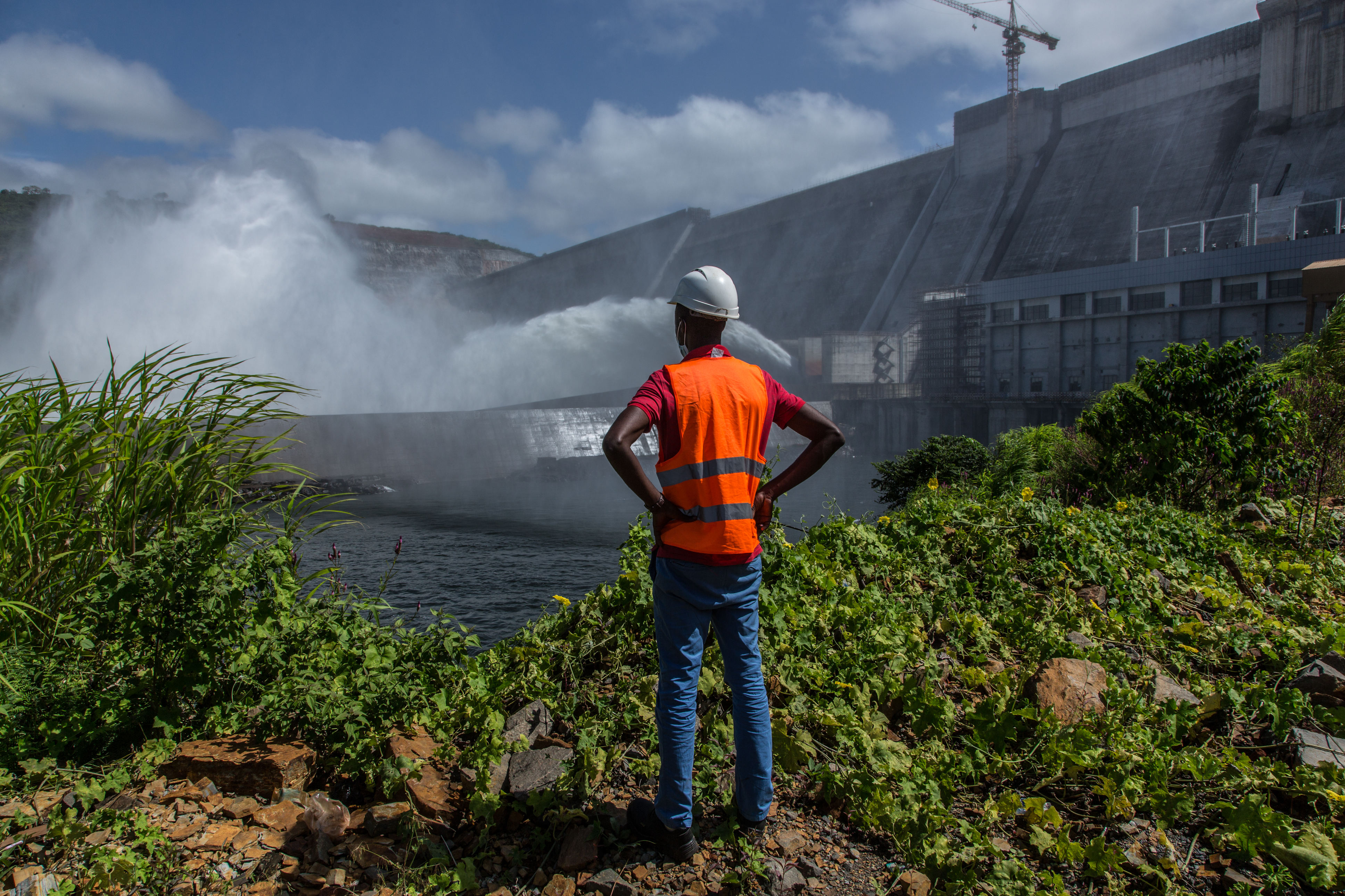 An engineer looks out over the 450-megawatt Souapiti hydropower dam in Conakry, Guinea. (Photo: Sadak Souici/ZUMA Press Wire. Conakry, Guinea – Oct 2020)