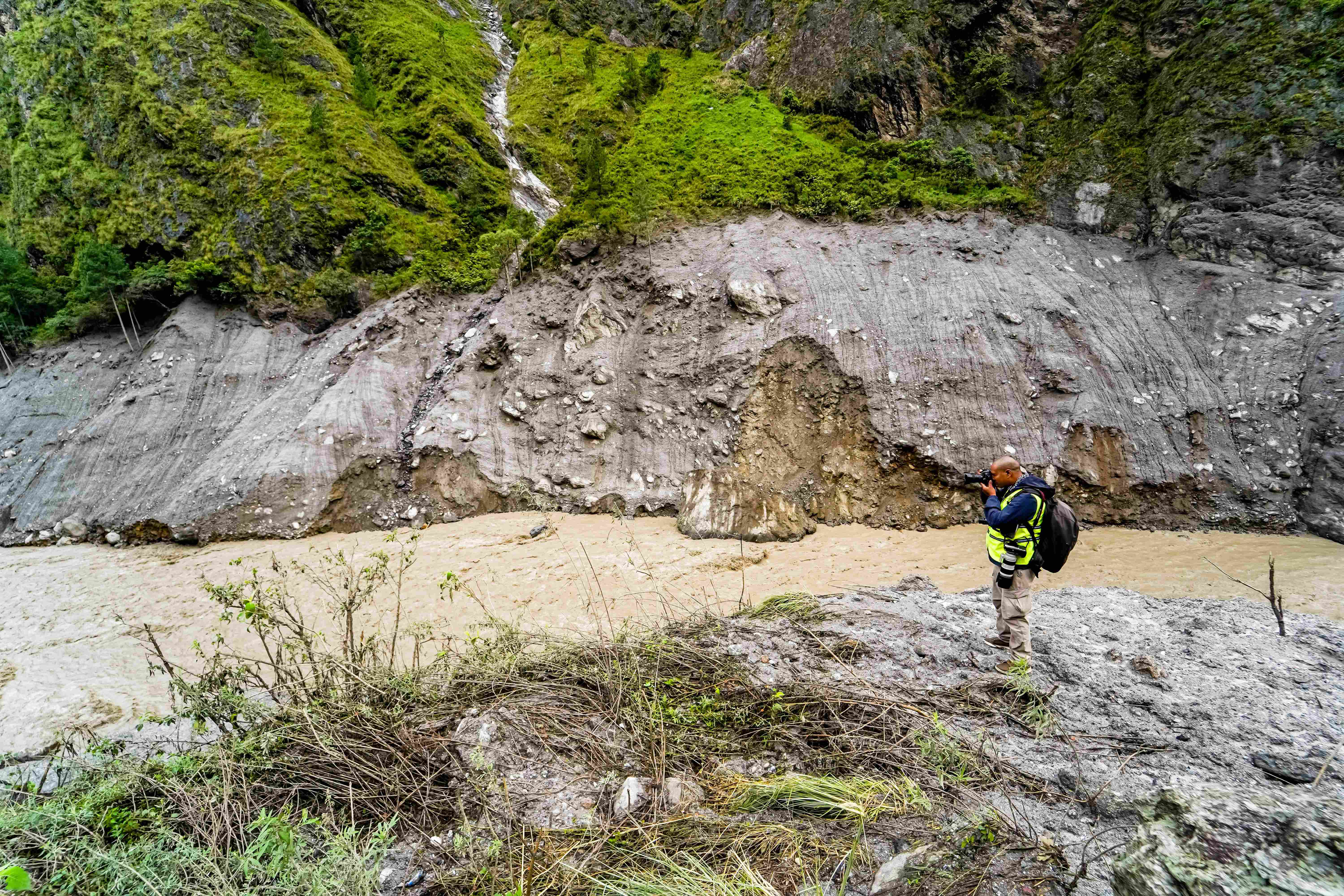 A reporter works in the field amid the aftermath of flooding along the Bhotekoshi River near Syabrubesi in Rasuwa, Nepal, where severe water damage ravaged the riverbank area following August 26 floods. (Photo: Ambir Tolang/NurPhoto. Rasuwa, Nepal – Sep 01, 2026)