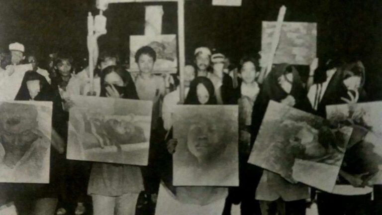 1986 rally against the Marcos Dictatorship in which protesters hold up images of Escalante Massacre victims. (Public Domain)