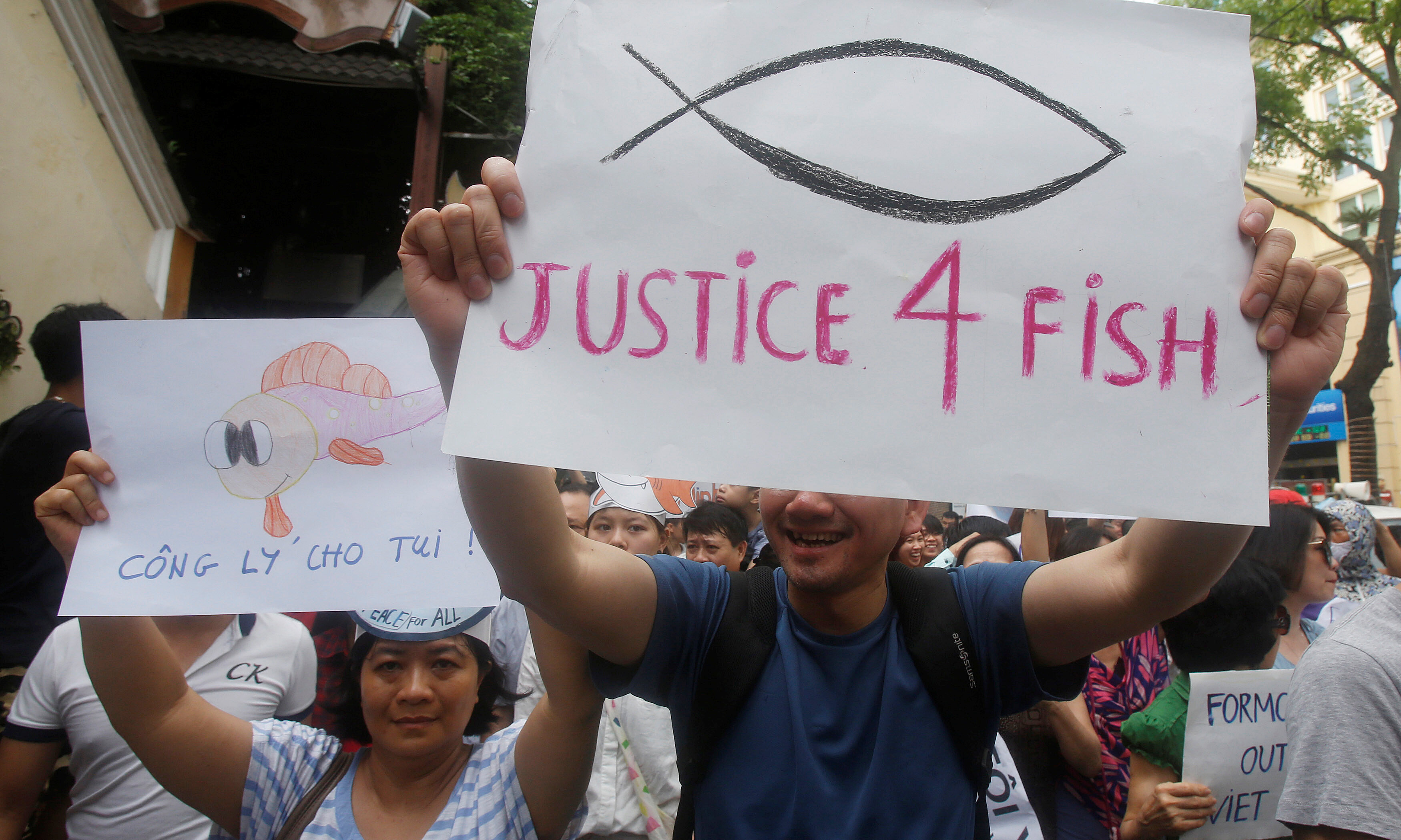Demonstrators, holding signs, say they are demanding cleaner waters in the central regions after mass fish deaths in recent weeks, in Hanoi, Vietnam May 1, 2016. REUTERS Kham