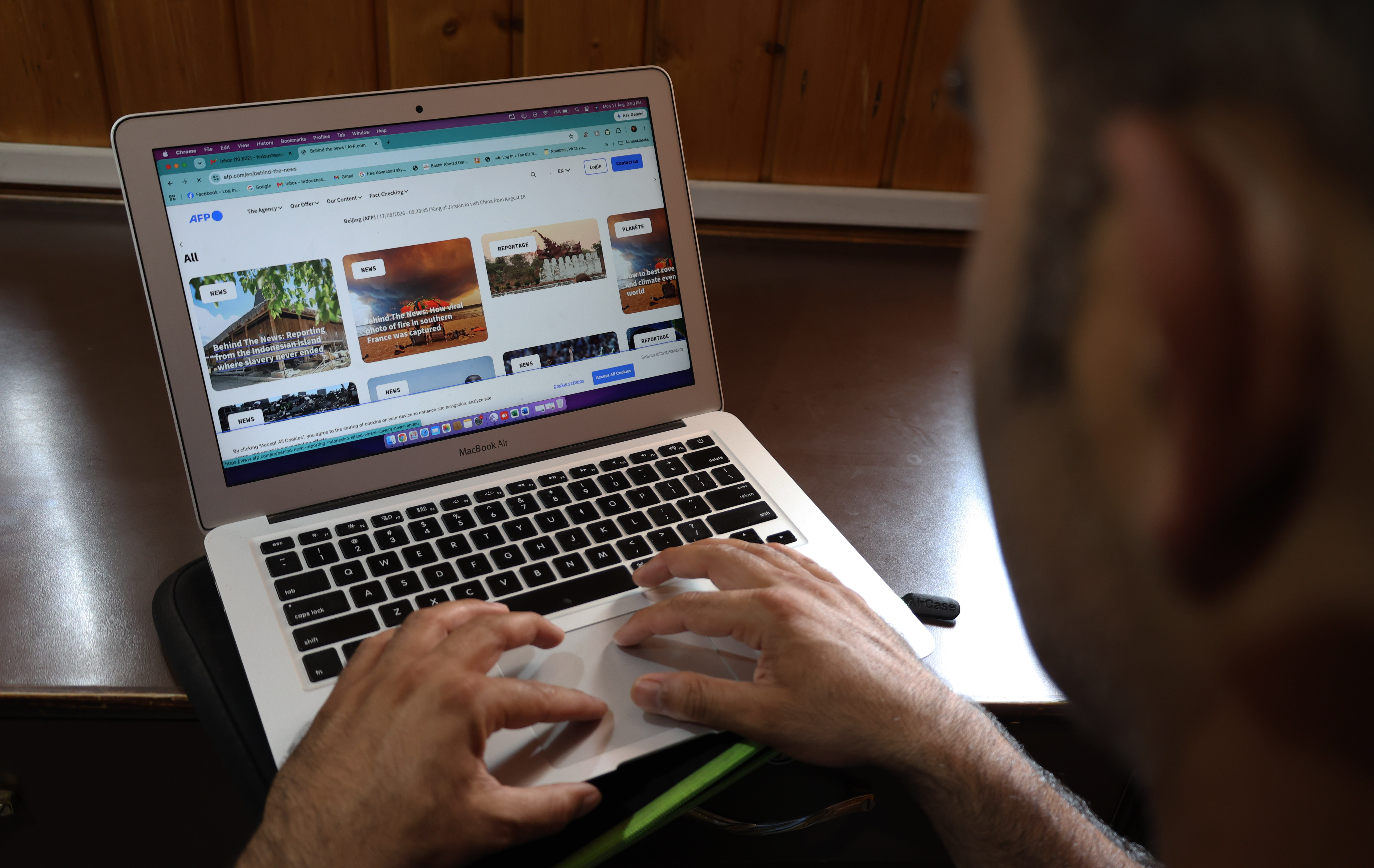 A user navigates a digital news portal on a laptop, illustrating the everyday consumption of global media in a connected world. Photo by Sajad Hameed