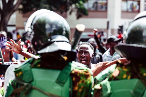 Maranga stands with a camera in Nairobi during the Gen–Z protest.