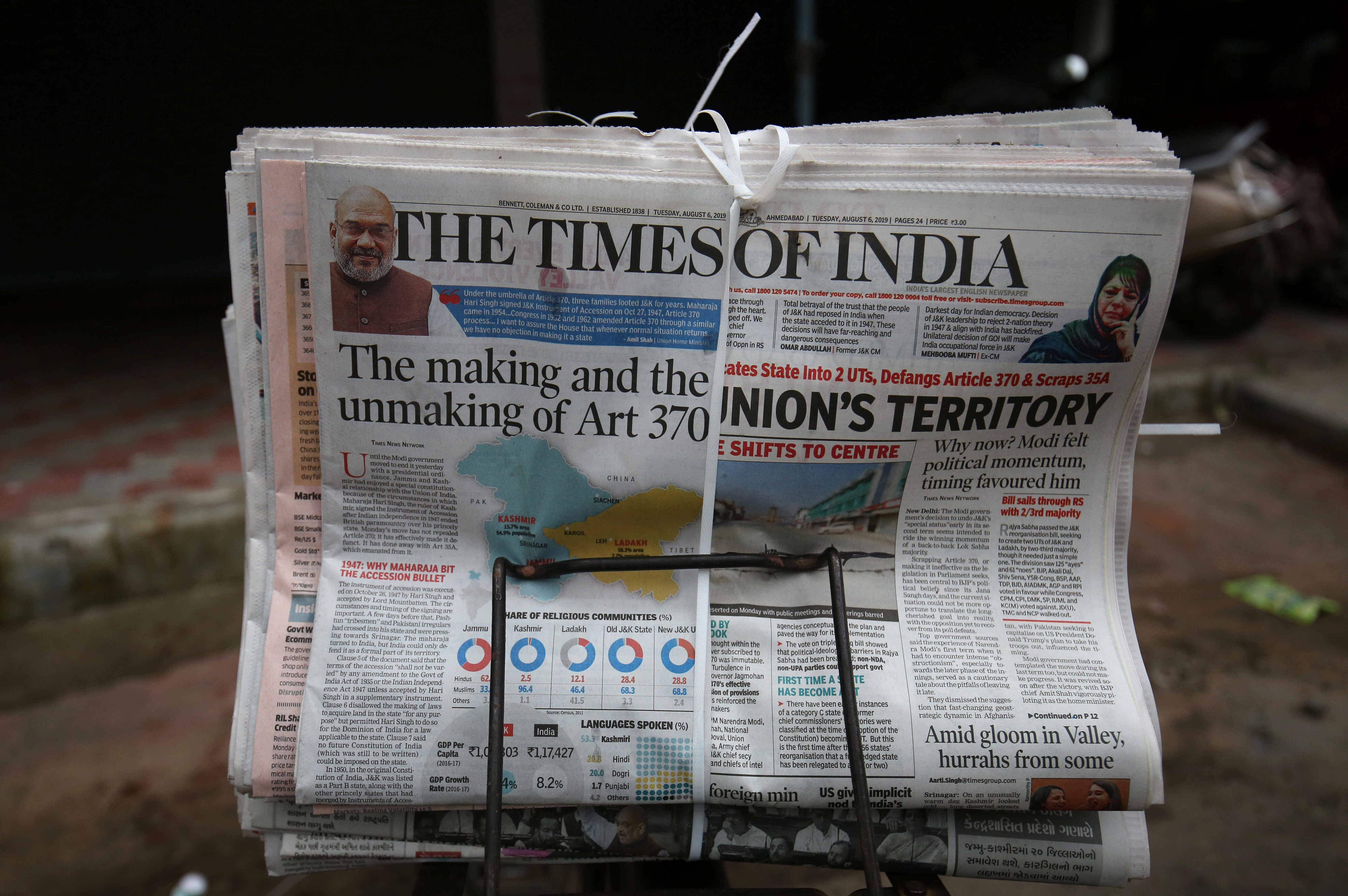 A newspaper for sale, with headlines about Prime Minister Narendra Modi's decision to revoke special status for the disputed Kashmir region, is tied to a cycle carrier at a pavement in Ahmedabad, India, August 6, 2019. REUTERS/Amit Dave