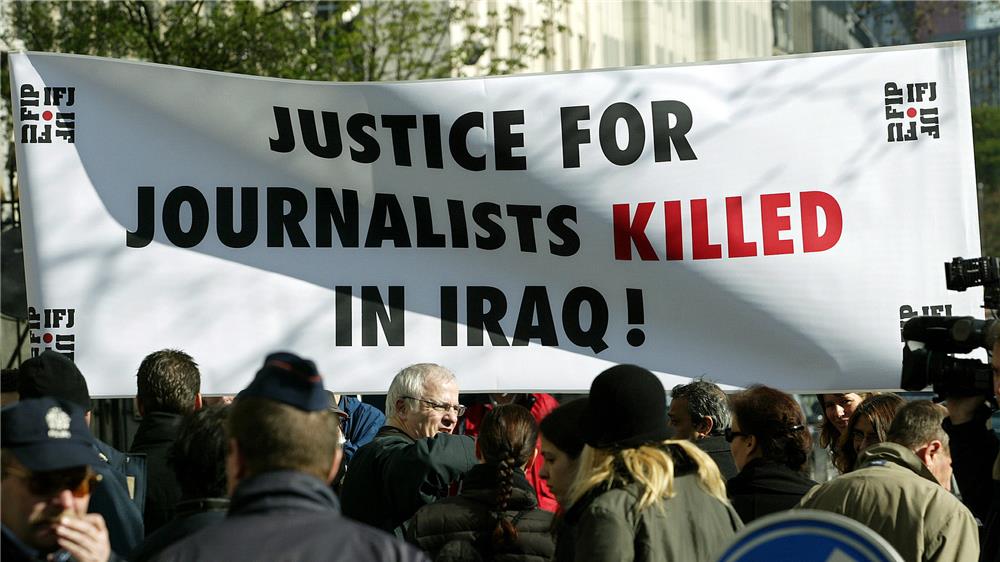 أعضاء من الاتحاد الدولي للصحفيين يتظاهرون أمام سفارة الولايات المتحدة في بروكسل، احتجاجا على تورط القوات الأميركية في مقتل 7 صحفيين، 8 أبريل/نيسان 2004 – رويترز.