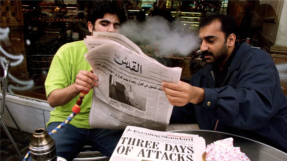 عربيّان يطالعان صحيفة القدس في لندن، إذ تتعمق العلاقة بين المغتربين العرب والصحف الورقية في الغربة رويترز.