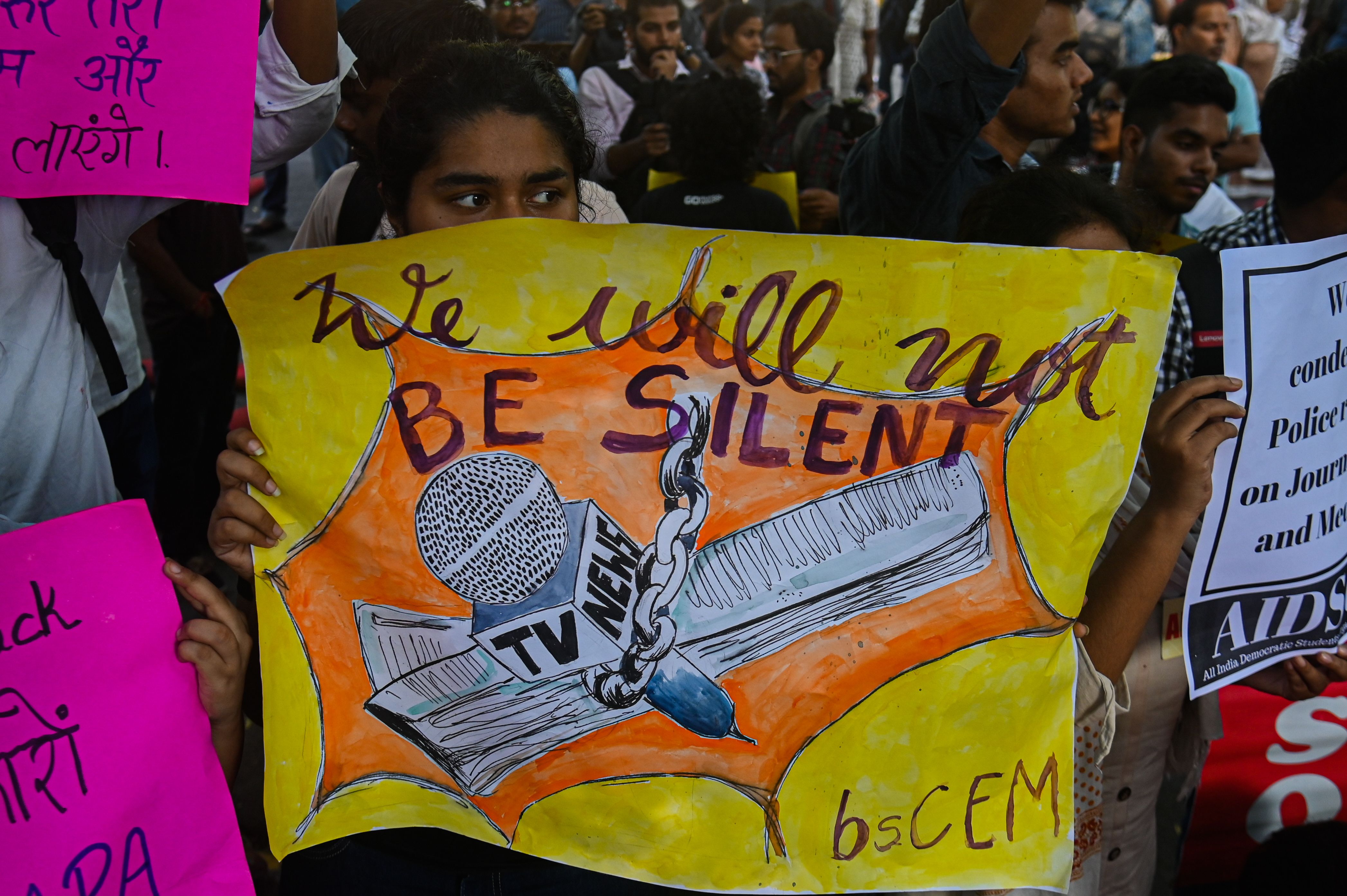 A demonstrator holds a hand-painted placard during a protest against police raids on media houses, symbolizing the growing resistance against the censorship and legal intimidation that threaten independent reporting across the country. (Photo: Kabir Jhangiani. India – Oct 2023)