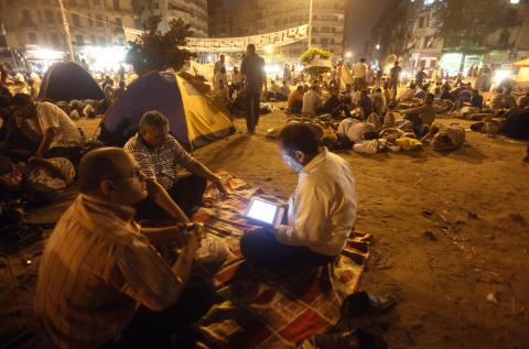  ساهمت ثورة مواقع التواصل الاجتماعي في تعزيز ثقافة الرقمنة للمحتويات العربية، إلا أنها خلقت مشكلة جديدة تمثلت فيما يعرف بالـ (franco-arabe). الصورة لأحد المتظاهرين في ميدان التحرير في مصر  وهو يقرأ من جهاز لوحي IPad. تصوير: أسماء وجيه - رويترز.