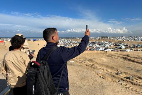 Gaza's citizen journalists take pictures over a hill. 