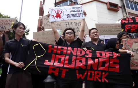 Members of the press hold placards during a rally to mark World Press Freedom Day in Kuala Lumpur, Malaysia, Thursday, May 3, 2012. Members of the Malaysian press protested on Thursday against the attacks on members of the media by police during Saturday's rally. (AP Photo/Lai Seng Sin)