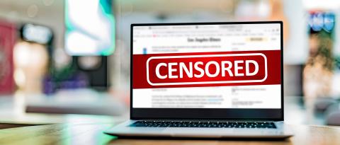 Laptop screen on table with the word "censorship" on the screen