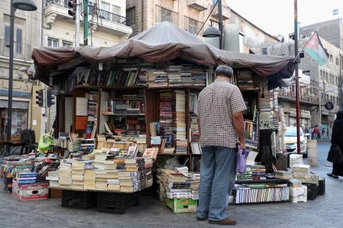A man stands in front of a street bookstore 