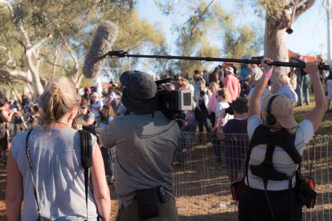 A large group of Western Journalists in the field waiting for a statement 