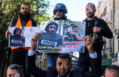 Supporters of Palestinian photographer Muad Amarna, who was hit in the eye with a bullet during clashes between Israeli border police and Palestinian demonstrators in the village of Surif near Hebron, demonstrate in front of a West Bank Israeli checkpoint on Nov. 18, 2019. 
