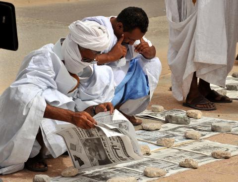 Mauritanians read newspapers on a main street in Nouakchott