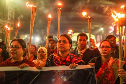 Members of the cultural organisation Udichi take part in a torch procession protesting arson attacks on the offices of Prothom Alo, The Daily Star, Chhayanaut and Udichi, in Dhaka, Bangladesh, on December 23, 2025.
