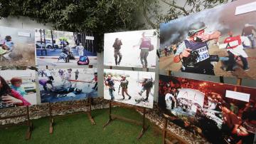 Palestinians participate in a photo exhibition to support Palestinian journalists against Israeli attacks in Gaza city 